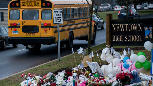 A school bus passes a memorial to the victims of the Sandy Hook Elementary School shooting in Newtown, Connecticut, on December 18th, 2012.