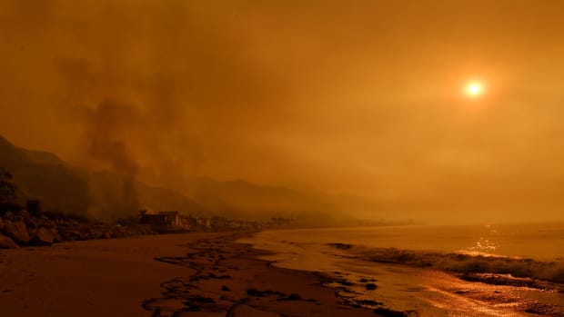 Heavy smoke covers the seaside enclave of Mondos Beach beside the 101 highway as flames reach the coast during the Thomas wildfire near Ventura, California, on December 6th, 2017.