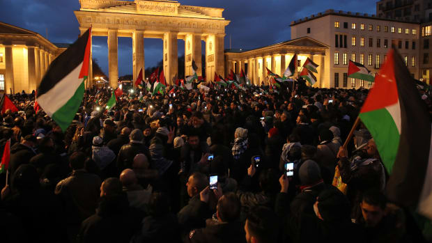 People waving Palestinian and Turkish flags gather in front of the Brandenburg Gate to protest against U.S. President Donald Trump's announcement to recognize Jerusalem as the capital of Israel on December 8th, 2017, in Berlin, Germany.