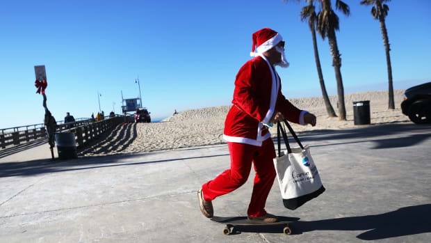 Jake Glaser, dressed as Santa Claus, skateboards at Venice Beach on December 13th, 2017, in Los Angeles, California. Residents are preparing for Christmas in the wake of a series of destructive wildfires across Southern California.