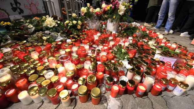 Candles and flowers are displayed outside a grocery store on January 2nd, 2018, where a 15-year-old girl was stabbed to death by her ex-boyfriend in the western German town of Kandel.