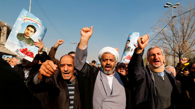 Iranian pro-government protesters, holding up portraits of Sajjad Shahsanai, a young member of the Revolutionary Guards killed in unrest in the city of Najafabad, shout slogans during a march after the weekly Friday prayers in Tehran on January 5th, 2018.