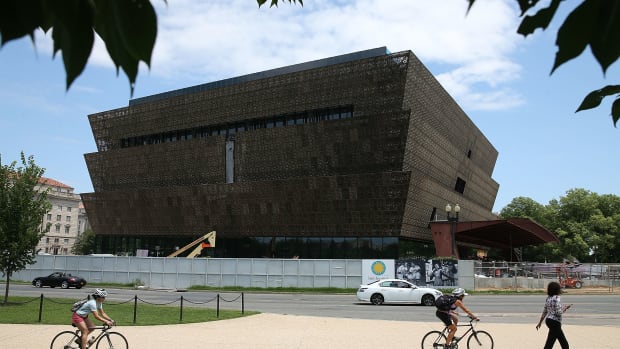 Tourists move past the Smithsonian Museum of African American History & Culture.