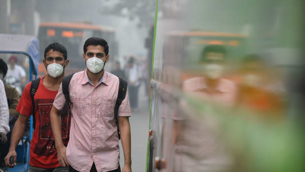 Commuters wear masks as they walk along a road amid heavy smog in New Delhi, India, on November 9th, 2017.