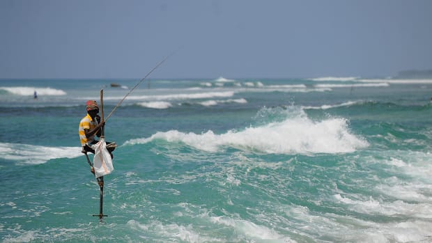 A Sri Lankan stilt fisherman works on his pole in the southern town of Galle.