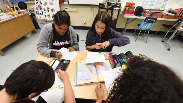 Students work on a project identifying countries in North, Central, and South America during a history class.