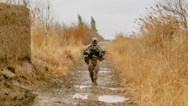 A Marine from the author's squad walks down a muddy goat trail on patrol in Marjah during the spring of 2011.