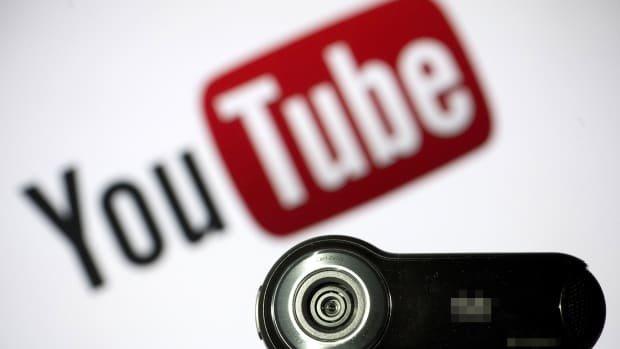 A webcam is pictured in front of the YouTube logo.