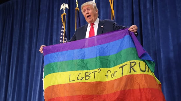 Then-nominee Donald Trump holds an LGBT rainbow flag at a campaign rally in Colorado in October of 2016.