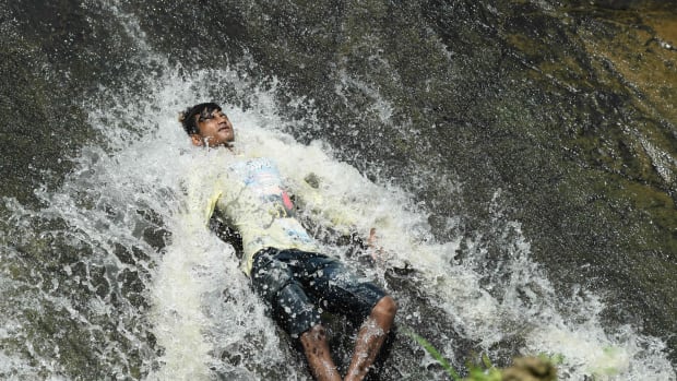 An Indian boy cools off in a waterfall during a hot summer day at the Basistha area in Guwahati, India, on June 13th, 2019. India is experiencing one of the longest and most intense heat waves in decades. Temperatures as high as 123 degrees have been recorded. The heat wave has led to at least 36 deaths since it began last month.
