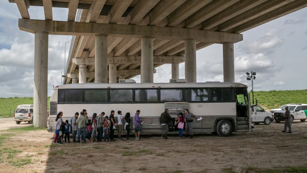 Immigrants wait to be transported to a U.S. Border Patrol processing center after they were taken into custody on July 2nd, 2019, in McAllen, Texas. The immigrants, mostly families from Central America, turned themselves in to border agents after rafting across the Rio Grande from Mexico to seek political asylum in the United States.