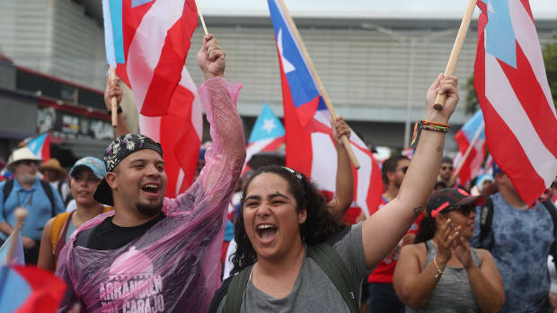 People march through the financial district as they celebrate the ousting of Ricardo Rosselló in Old San Juan, Puerto Rico.