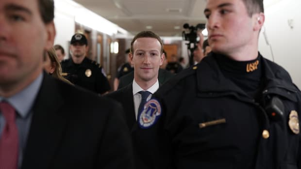 Mark Zuckerberg is escorted through the United States capitol.