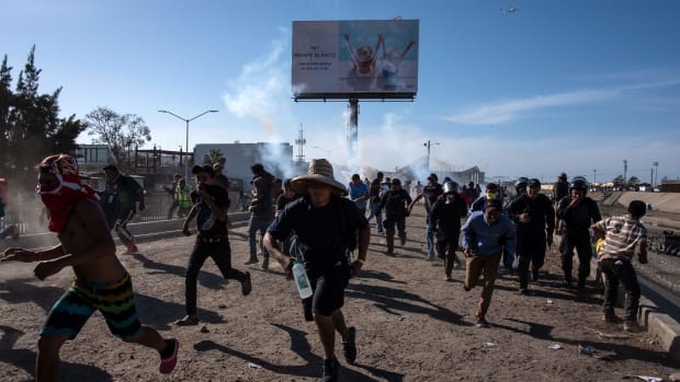 Central American migrants (mostly Hondurans) run along the Tijuana River near the El Chaparral border crossing in Tijuana, Baja California State, Mexico, near the U.S.–Mexico border, after the U.S. border patrol threw tear gas to disperse them after an alleged verbal dispute, on November 25th, 2018.