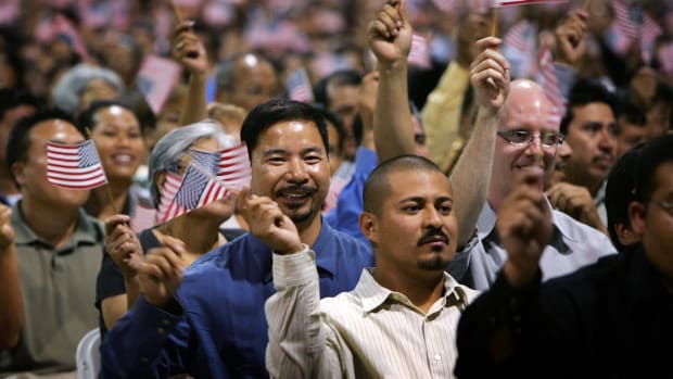 Immigrants wave flags after being sworn in as U.S. citizens in naturalization ceremonies on July 26th, 2007, in Pomona, California.