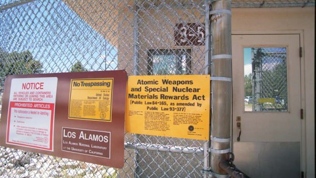 Signs are posted on the gated wall around the main technical area of Los Alamos National Laboratory, New Mexico.
