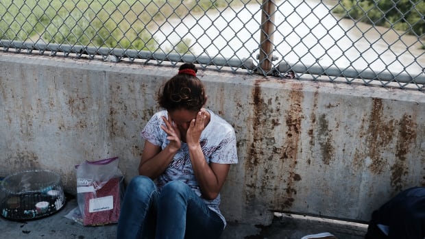 A Honduran woman waits along the border bridge after being denied entry into the U.S. from Mexico on June 25th, 2018, in Brownsville, Texas.