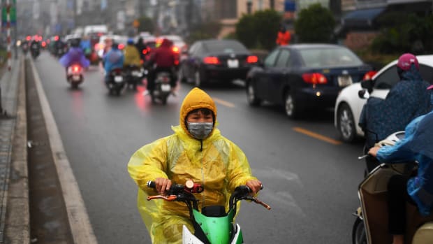 A young boy rides his electric scooter in the rain in Hanoi, Vietnam, on January 7th, 2019.