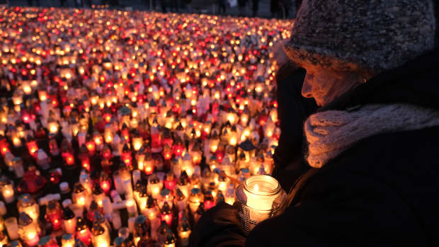 A mourner holds a candle for murdered Gdansk Mayor Pawel Adamowicz on January 17th, 2019, in Gdansk, Poland. Adamowicz was stabbed on stage while attending a charity event in Gdansk last Sunday and died a day later of his injuries. The suspect is a 27-year-old man with a criminal record who was taken into custody. The coffin carrying Adamowicz's body was displayed in the European Solidarity Centre late Thursday, where the public could pay last respects. Adamowicz's funeral is scheduled for Saturday, January 19th, 2019.