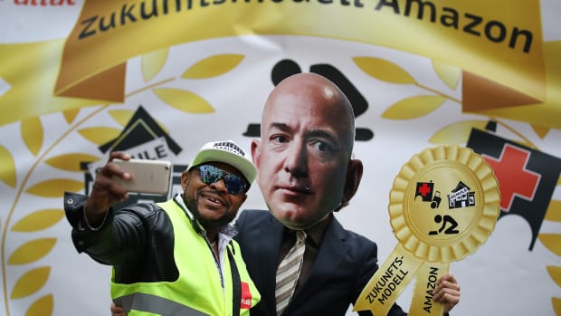 An Amazon warehouse worker shoots a selfie with an activist dressed as Amazon's Jeff Bezos during a protest outside the Axel Springer Building on April 24th, 2018, in Berlin.