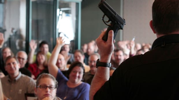 Firearm instructor Clark Aposhian holds a handgun up as he teaches a concealed-weapons training class to 200 Utah teachers in December of 2012. After the Marjory Stoneman Douglas High School shooting in Parkland, Florida, 14 state legislatures introduced bills calling to arm school staffs.