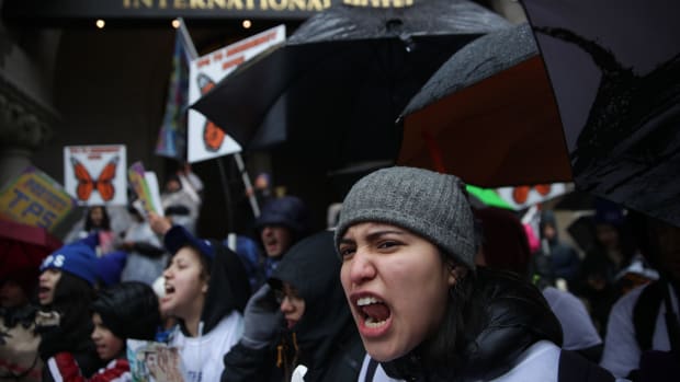 Immigration activists shout slogans as they protest outside Trump International Hotel during a march on February 12th, 2019, in Washington, D.C. Activists called on Congress to grant permanent protections to immigrants with Temporary Protected Status.