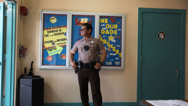 A Miami-Dade Police officer stands guard at the front entrance to the Kenwood K-8 Center in August of 2018 in Miami, Florida. In addition to armed police officers being present on school campuses, the school system has installed 15,000 high-definition cameras connected to a central command post as well as the Raptor system, which allows school personnel to check the criminal history of each school visitor.