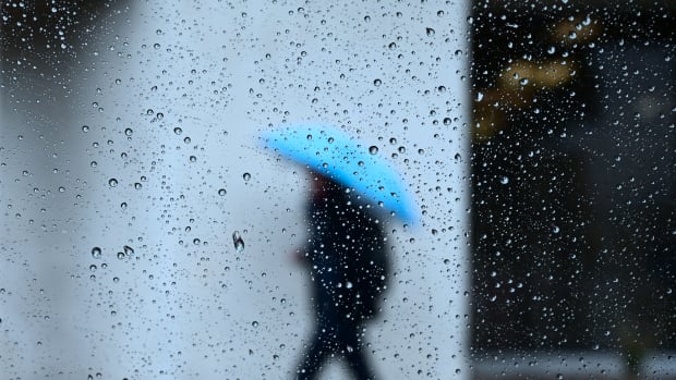 Raindrops are seen on a vehicle window as a pedestrian walks in the rain in Los Angeles, California on January 31st, 2019, as heavy rains hit southern California bringing thunder and lightning.