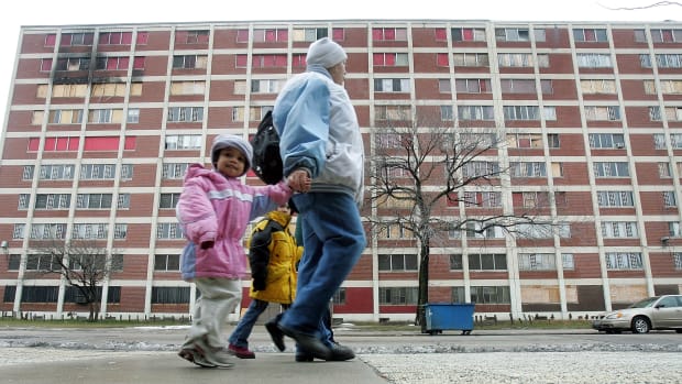 Residents walk past one of the few remaining Chicago Housing Authority Cabrini-Green public housing buildings January 12th, 2005, in Chicago, Illinois.