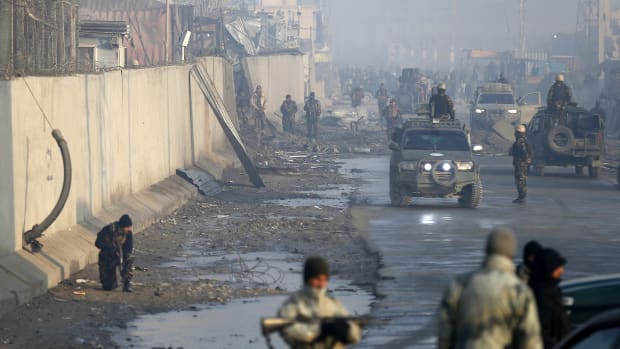 Afghan security forces gather in mid-January at the site of a powerful truck bomb attack, claimed by the Taliban, which killed four and wounded over 100.