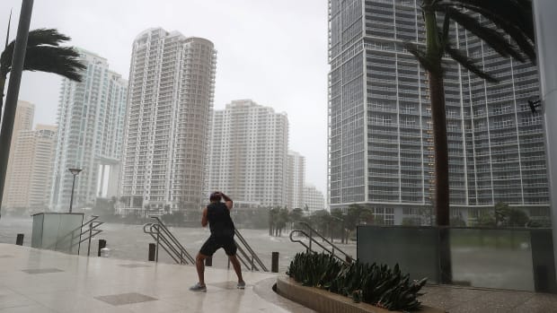 A person battles high winds and rain to take pictures of the flooding along the Miami River as Hurricane Irma passes through on September 10th, 2017, in Miami, Florida.
