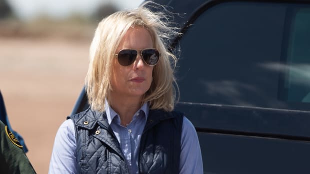 In this photo taken on April 5th, 2019, Secretary of Homeland Security Kirstjen Nielsen waits for President Donald Trump as he arrives to tour the border wall between the United States and Mexico in Calexico, California.