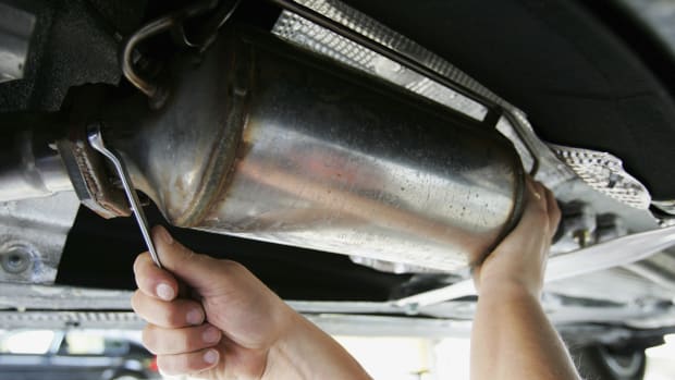 A car mechanic fits a particle filter to a diesel-engined car.