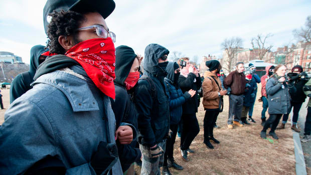 Anti-fascist counter-protesters form a circle around the helmeted members of a right-wing group during the Women's March at Boston Common in Boston, Massachusetts, on January 19th, 2019.