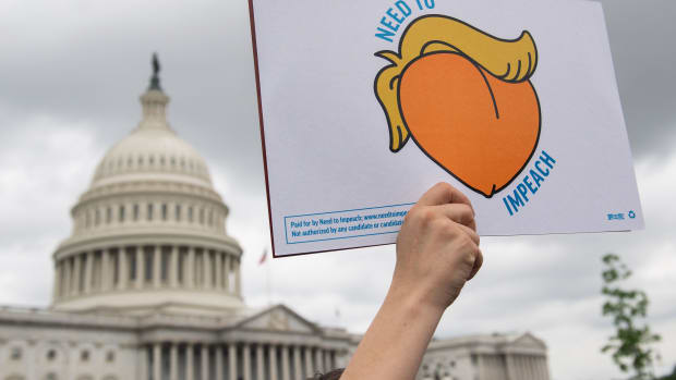 A woman holds a sign during a press conference where activists delivered a computer flash drive with 10 million signatures to lawmakers at the United States Capitol in Washington, D.C., on May 9th, 2019. The signatures were on a petition urging Congress to begin impeachment proceedings against President Donald Trump.