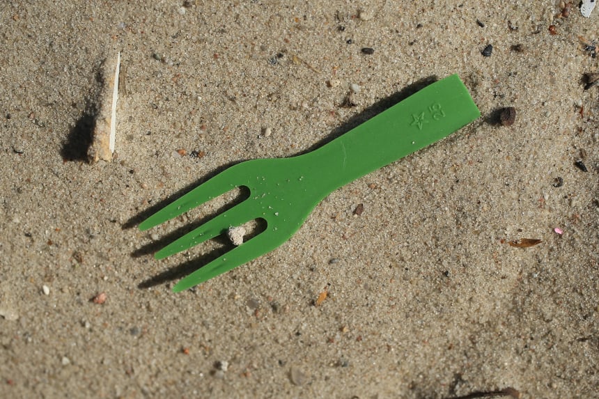 A plastic fork lies on a beach along the Spree River in the city center on May 29th, 2018, in Berlin, Germany.  Europe is struggling to combat plastics pollution in its waterways and seas.  He recently announced it will seek to ban the use of certain common plastic items, including plastic cutlery, straws, plates, swabs, and fishing gear.