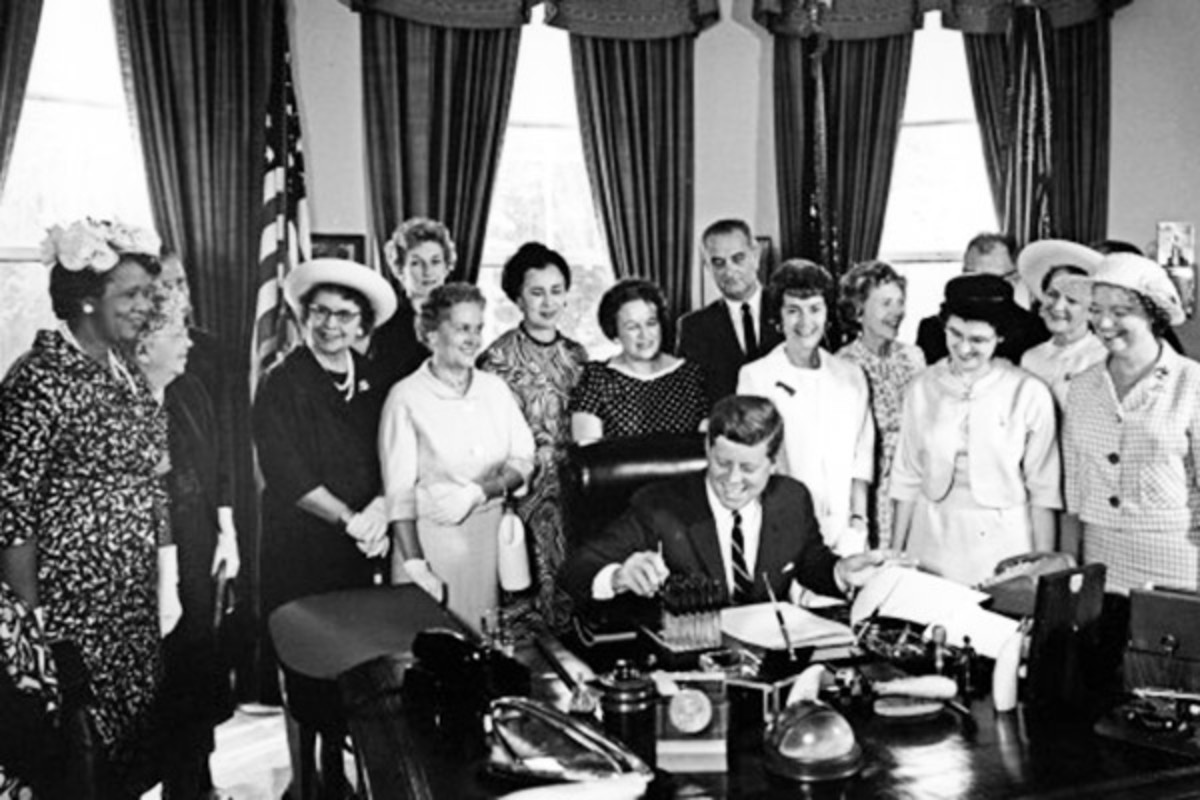 American Association of University Women members with President John F. Kennedy as he signs the Equal Pay Act into law. (PHOTO: PUBLIC DOMAIN)