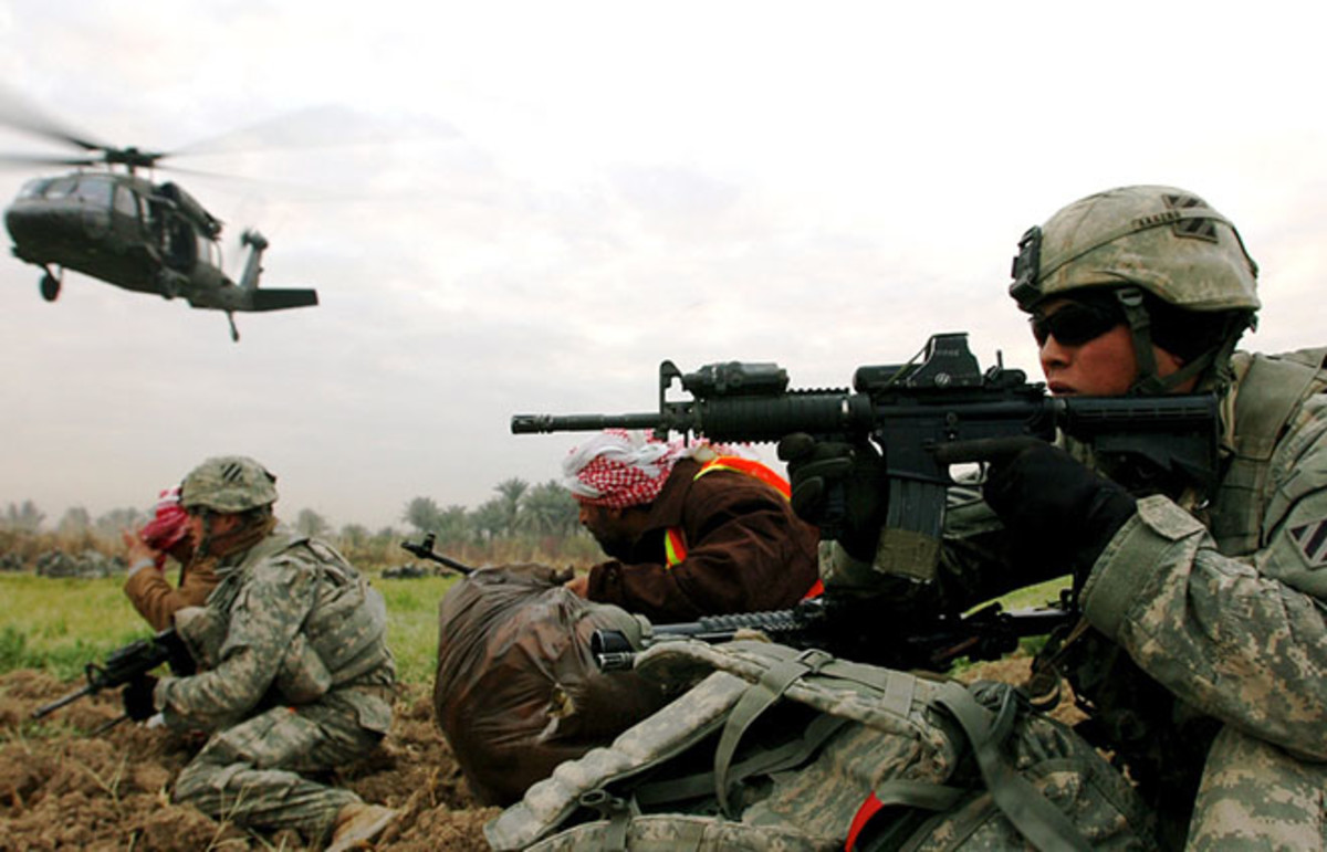 U.S. soldiers and Sunni Arab tribesmen scan for enemy activity in a farm field in southern Arab Jibor in January 2008. (Photo: Public Domain)
