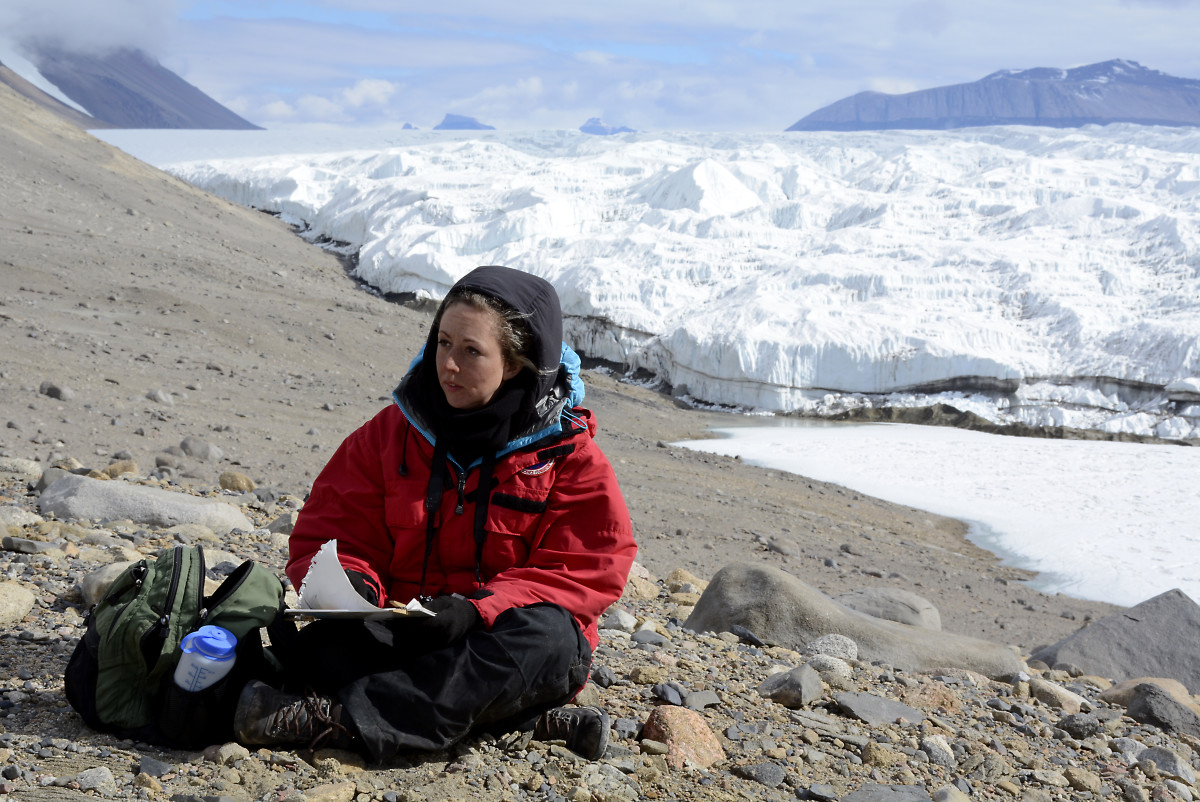 Sketching at Taylor Glacier in the McMurdo Dry  Valleys, January 2015. At night, Simonson bundled up her art supplies in  her sleeping bag to keep them warm. (Photo: Peter Rejcek)