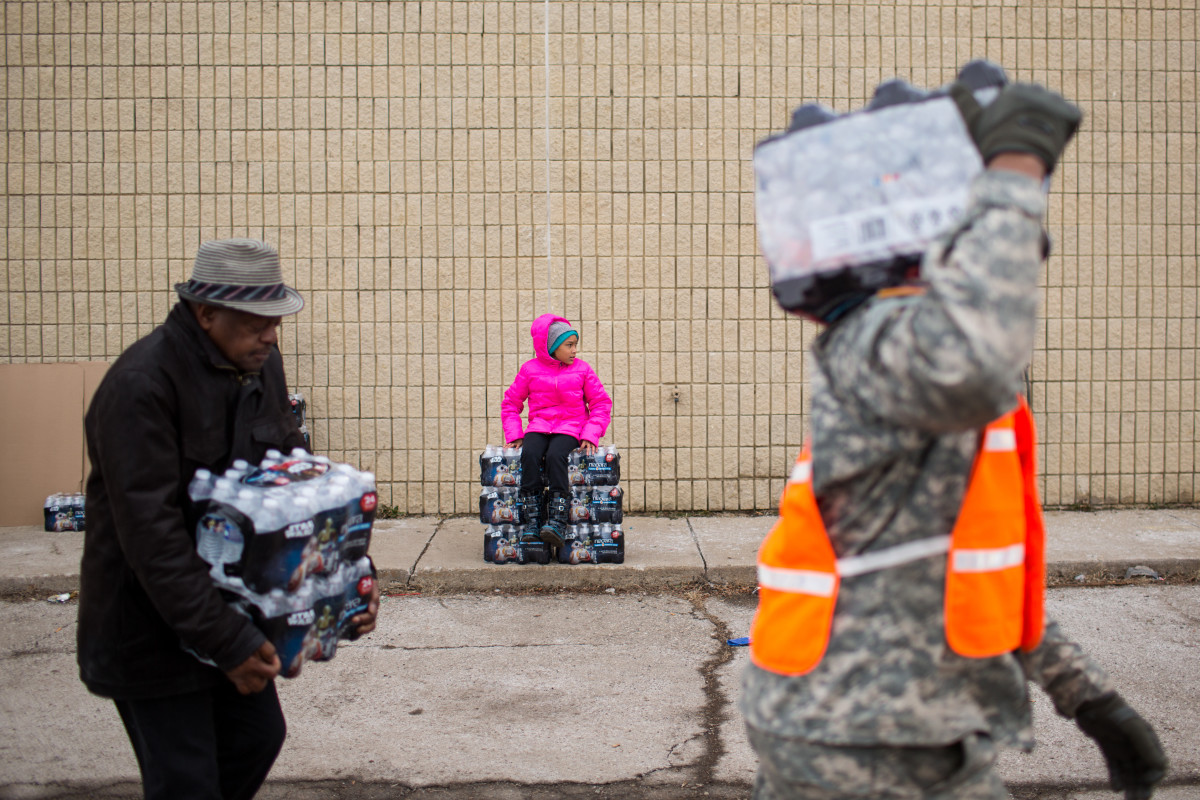 National Guard members and civilians carry cases of water to vehicles on January 23, 2016, in Flint, Michigan. (Photo: Brett Carlsen/Getty Images)