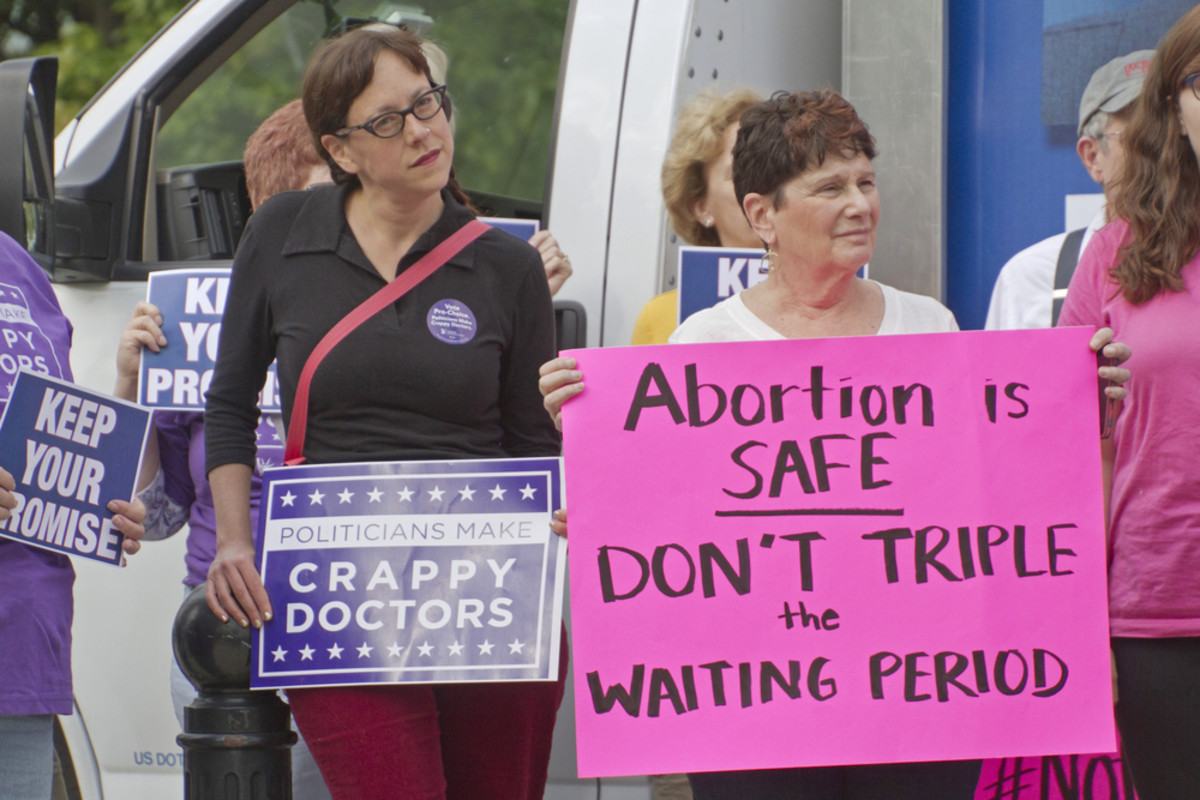 Women hold signs protesting North Carolina's  abortion Bill #465, which increases restrictions for women seeking  abortions, in Asheville on May 4, 2015. (Photo: J. Bicking/Shutterstock)