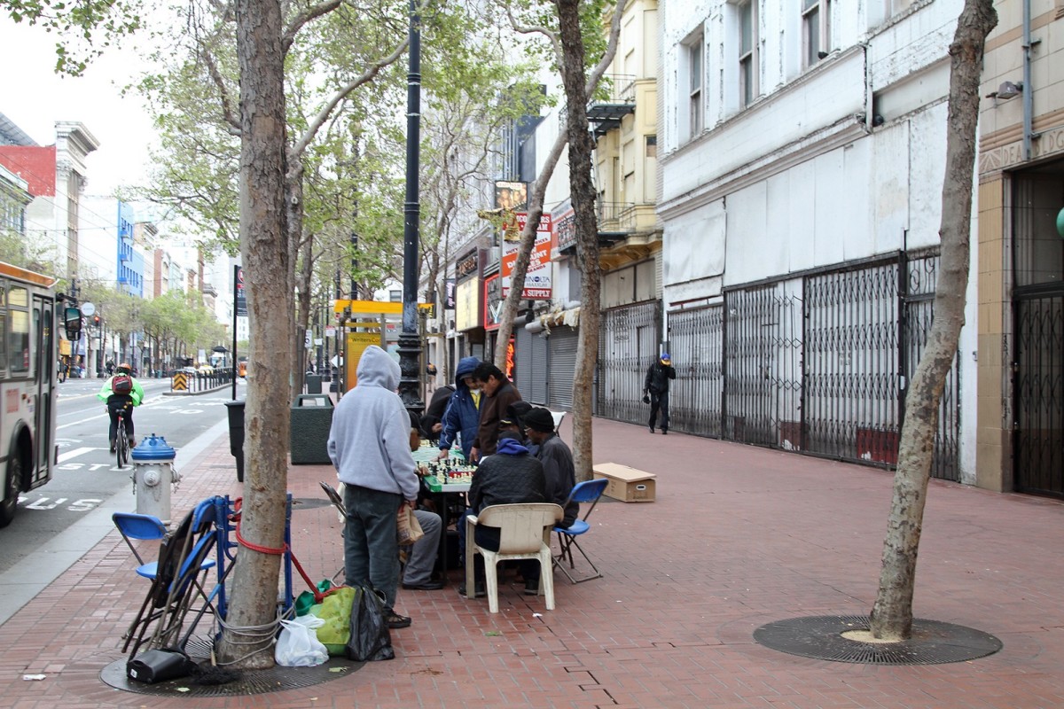 People play chess in the early evening along Market St. in the Tenderloin neighborhood of San Francisco, California.