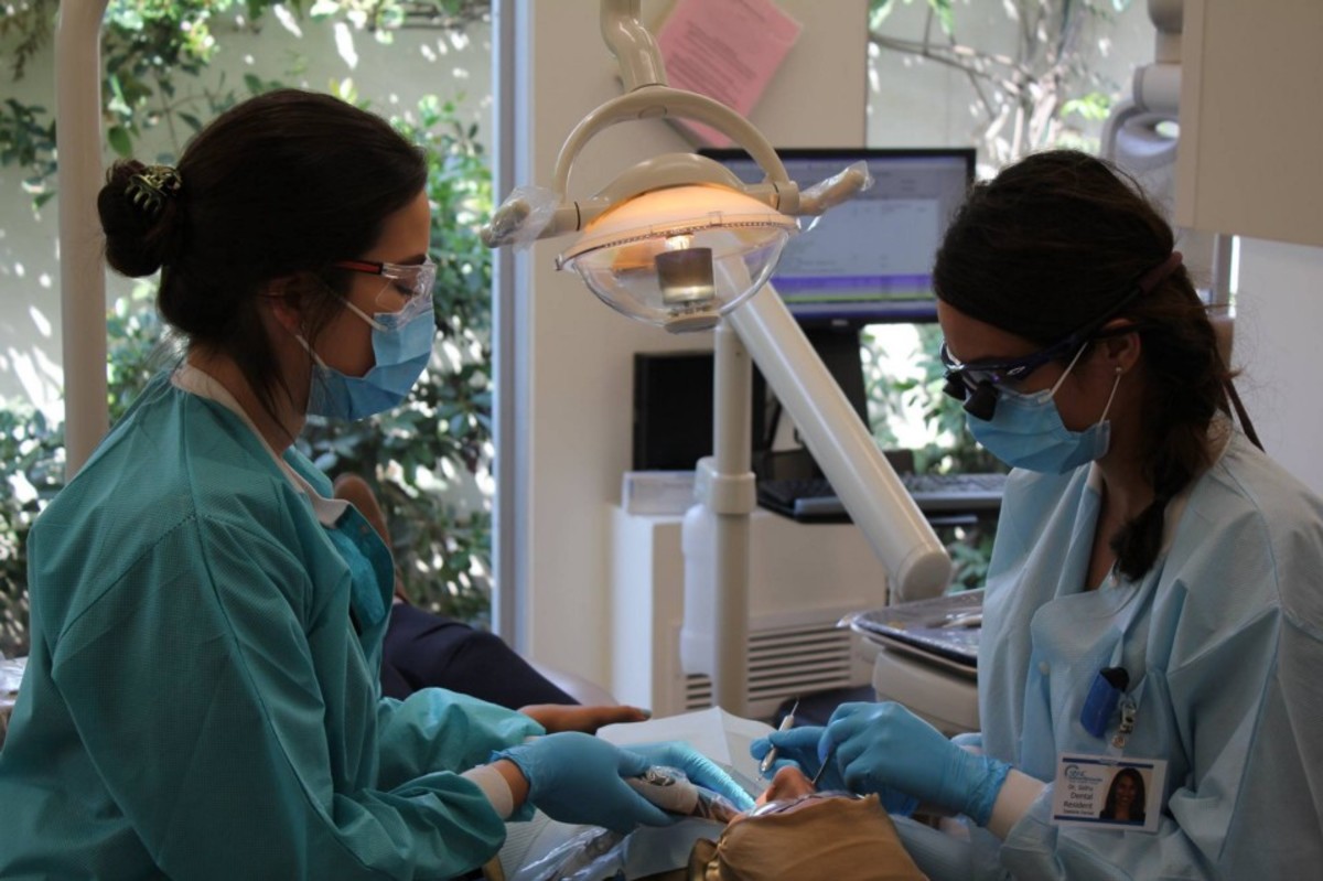 Photo showing a dentist and assistant examining a patient