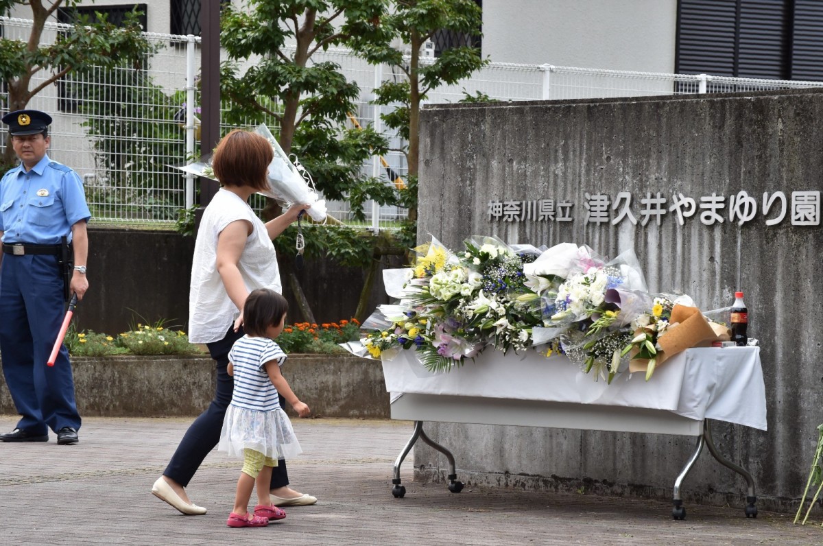 A mother and her daughter offer flowers for the victims of a knife rampage at the Tsukui Yamayuri En care centre on July 28, 2016, in Sagamihara, Kanagawa Prefecture, Japan. (Photo: Kazuhiro Nogi/AFP/Getty Images, via David Perry)
