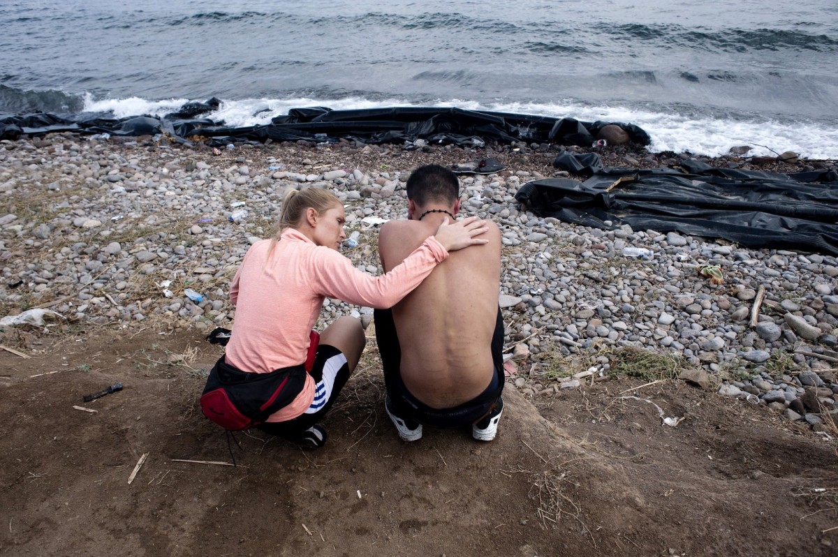 A volunteer tries to console a refugee on Sykamia beach, on the Greek island of Lesbos.