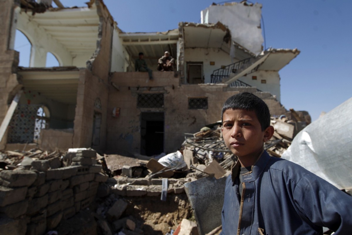 A boy stands near the rubble outside a house destroyed by Saudi-led airstrikes on the outskirts Sana'a, Yemen.