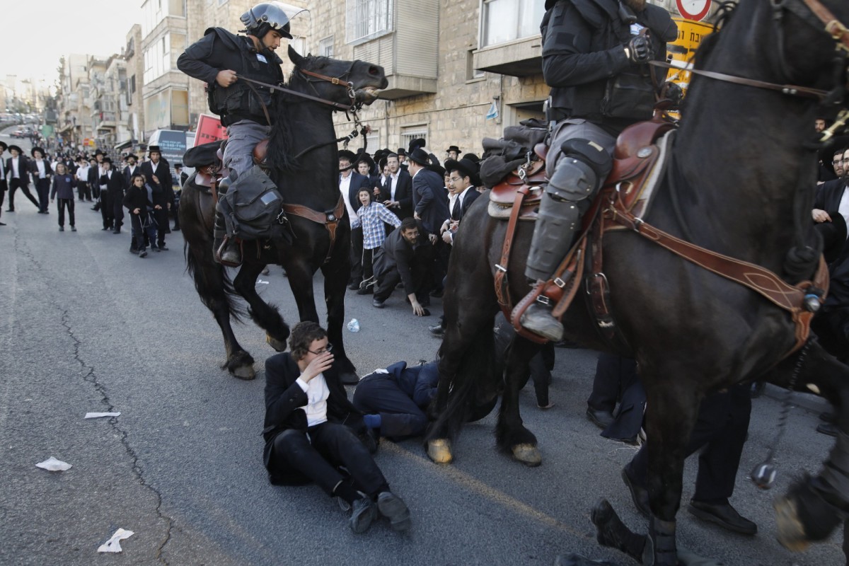 Mounted policemen disperse Orthodox Jews in the center of Jerusalem during a protest against Israeli army conscription on April 3rd, 2017. (Photo: Menahem Kahana/AFP/Getty Images)