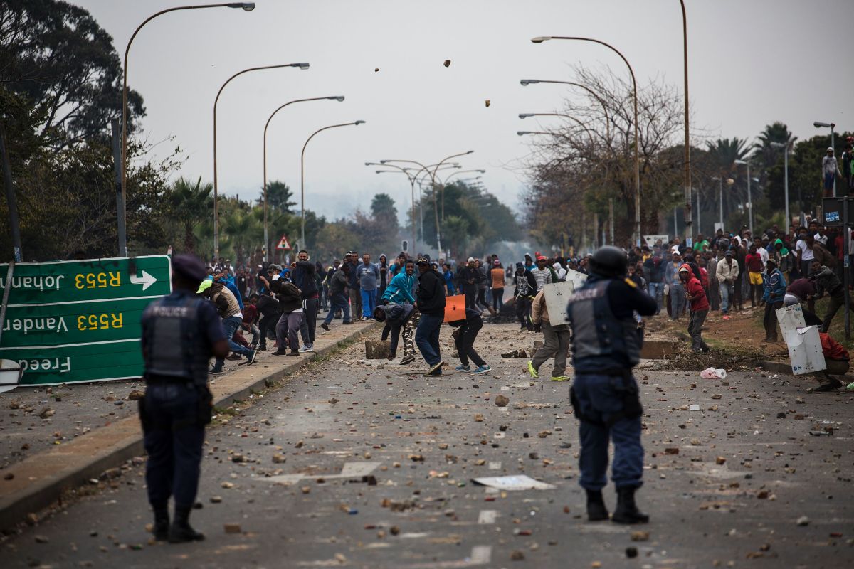 Residents throw stones during clashes with riot police in Johannesburg, South Africa, on May 8th, 2017, following a demonstration over land grabbing, housing, and unemployment in the area.