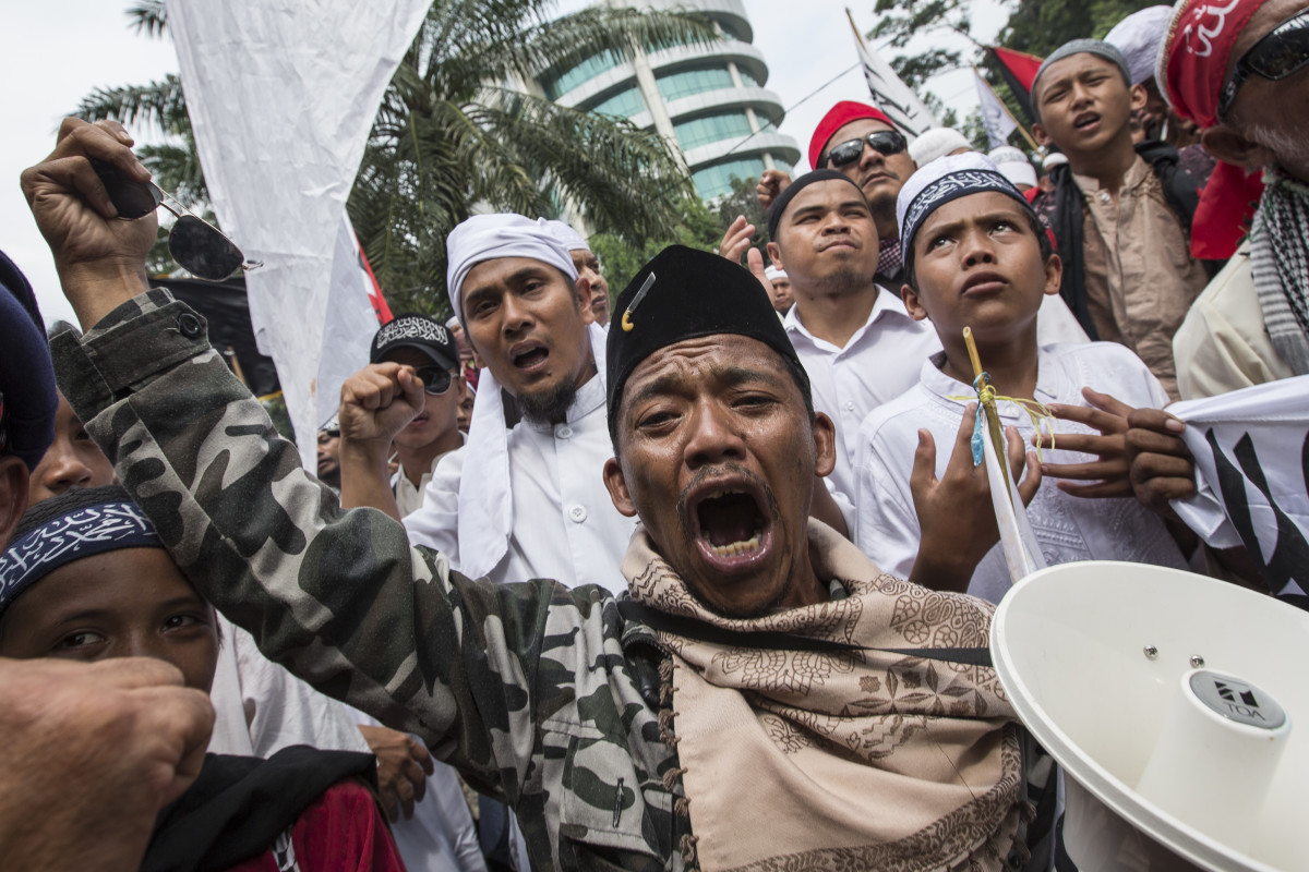 Members of various hardline Muslim groups celebrate after Jakarta's former governor, Basuki Tjahaja Pernama, was convicted of committing blasphemy.