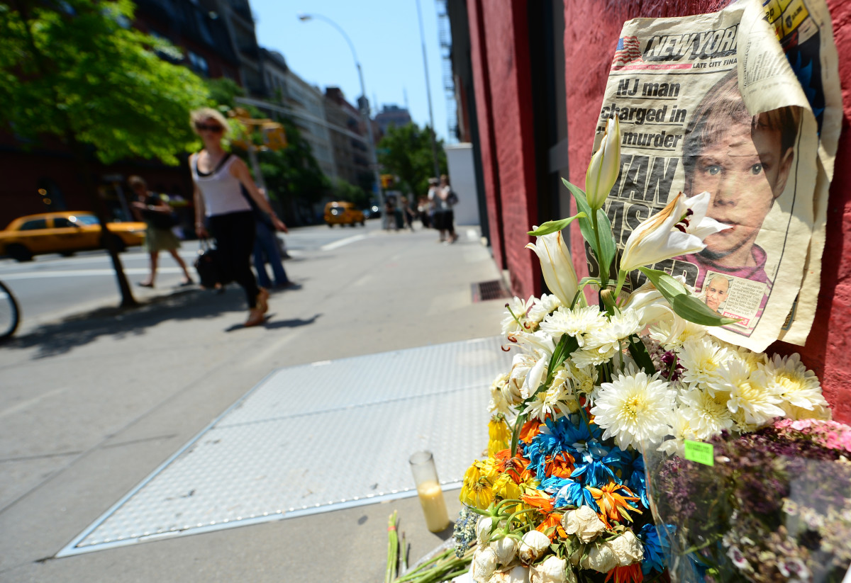 People walk past a street shrine to six-year-old Etan Patz, who disappeared 33 years ago, set in front of the building where suspect Pedro Hernandez confessed to having strangled the boy in New York.